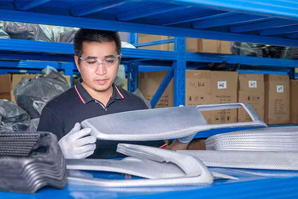 a worker checking the quality of carbon fiber car parts