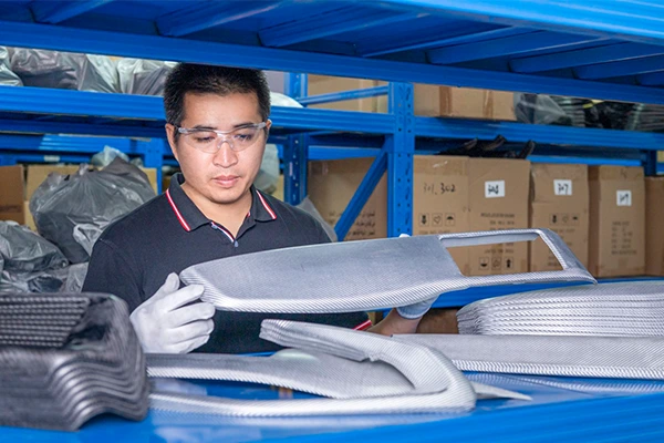 Un trabajador que controla la calidad de las piezas de automóviles de fibra de carbono.