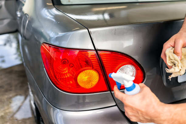 Menschen reinigen das Auto mit einer Spraydose und Stoff